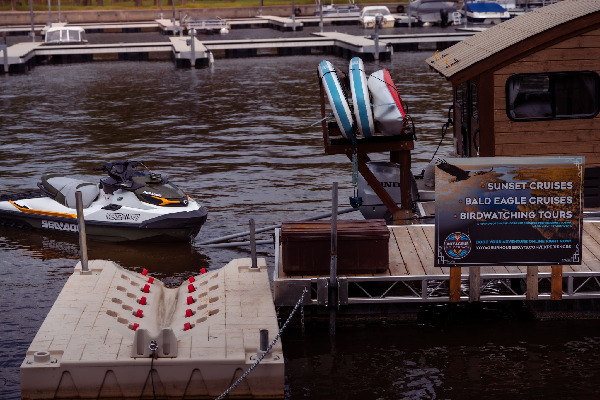 Marina dock with boats and equipment against dark water.