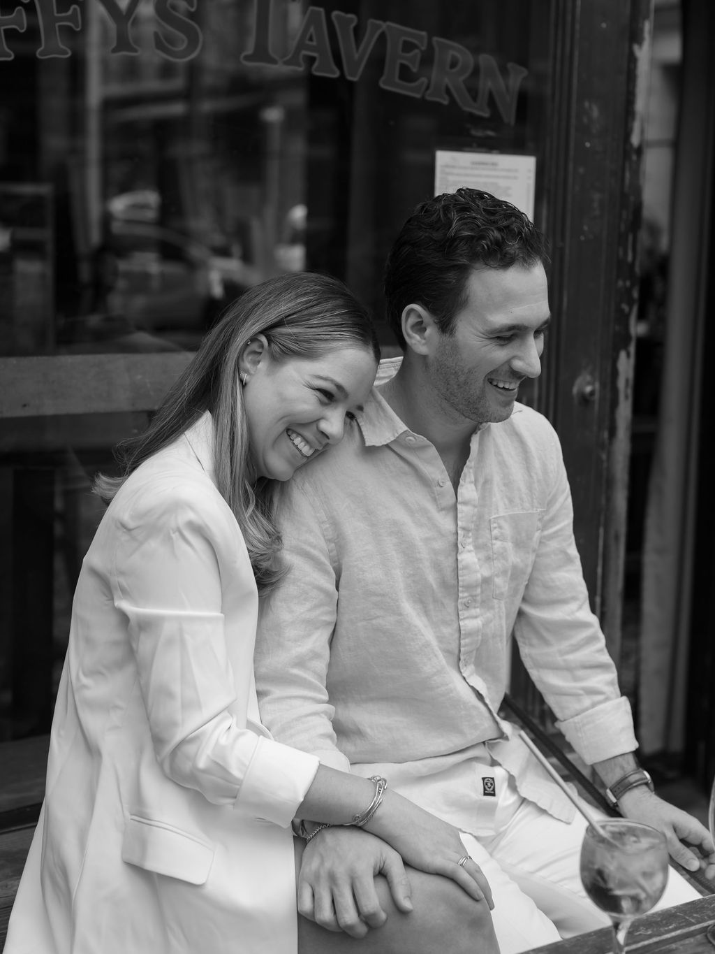 Black and white candid shots of people laughing outside tavern.