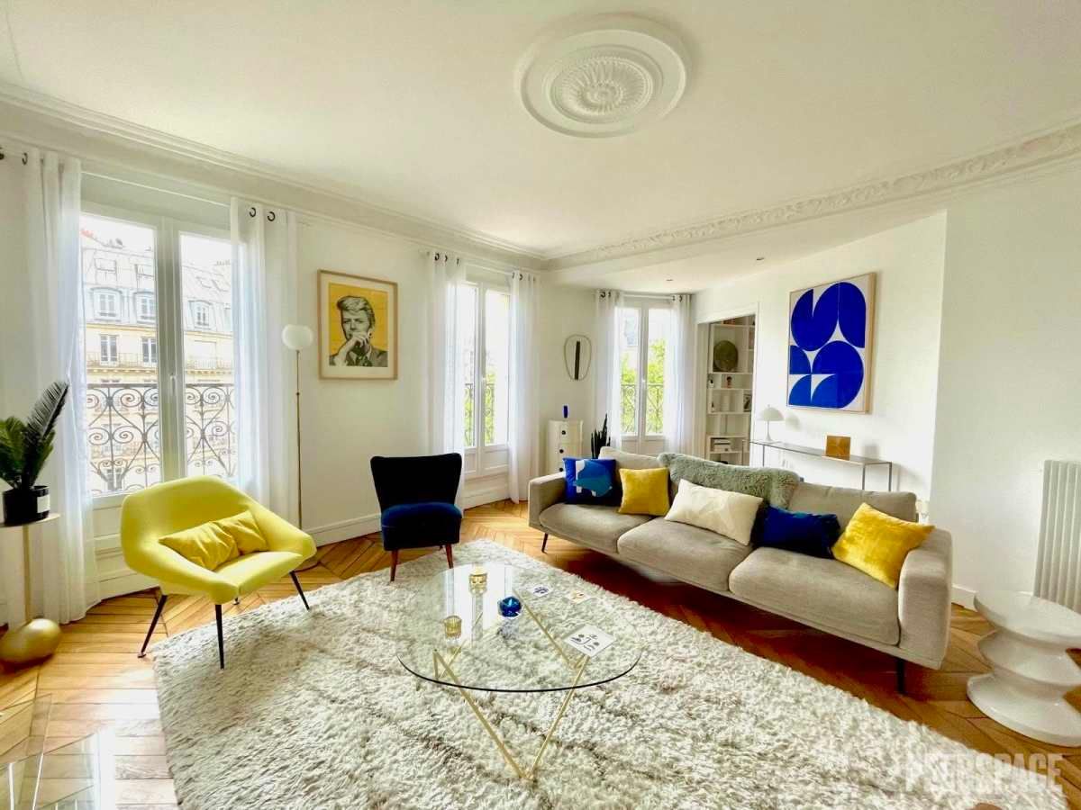 Portrait d'une coach dans un appartement haussmannien lumineux avec cheminée à Paris