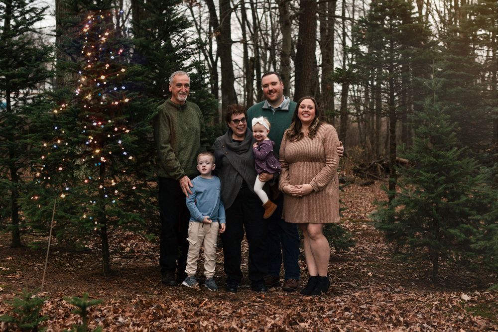Natural light Christmas portraits focused on authentic family connection. Outdoor holiday family photos taken in a snowy park setting. Holid