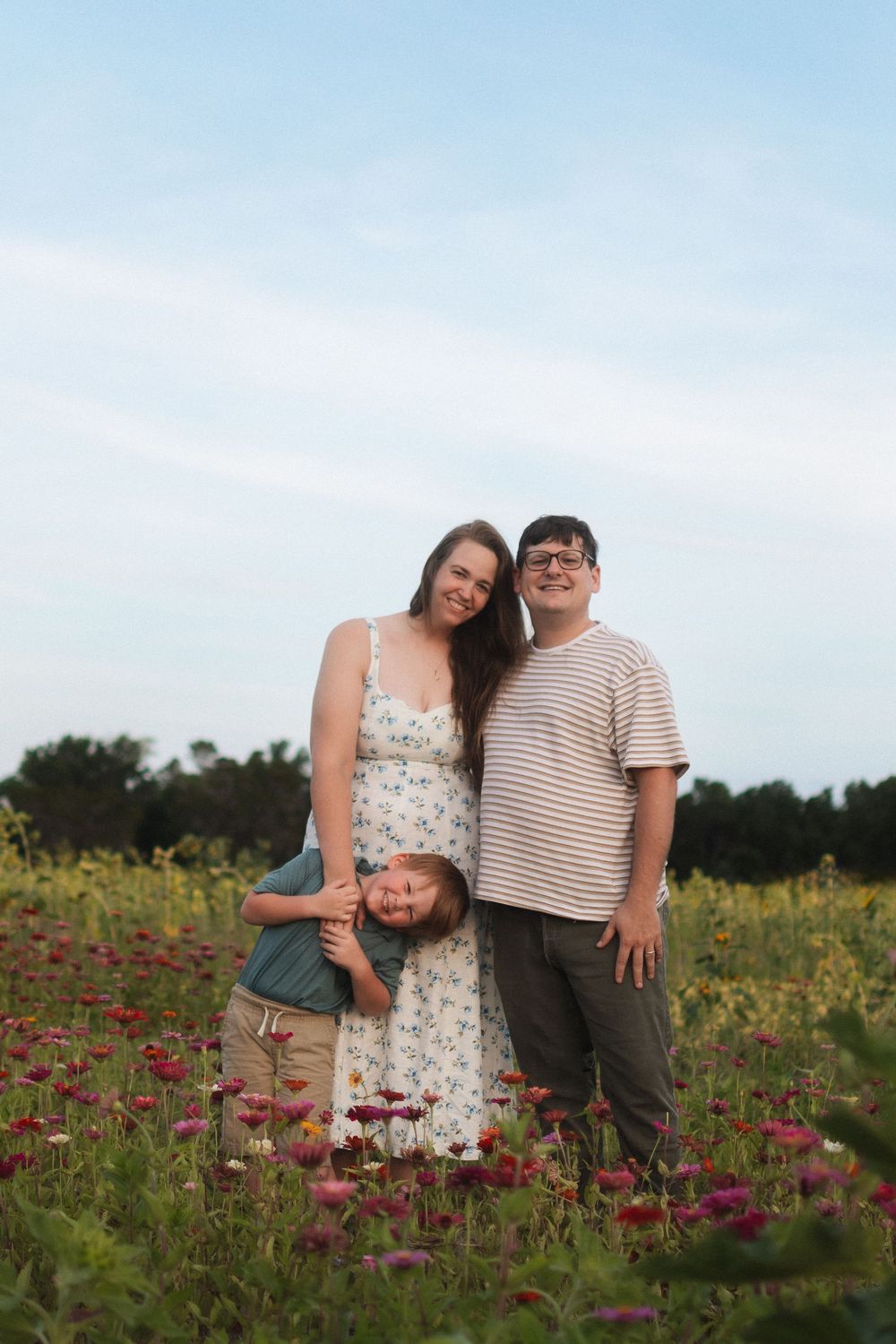 Family of three in flower fields at Fancy Farms Market, Plant City, Florida by a Central Florida family photographer.