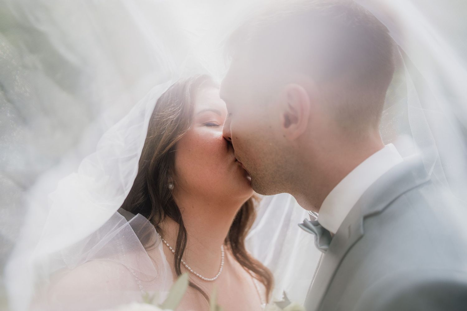 Wedding photo series showing romantic moments under soft lighting and veil.