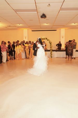 Wedding reception dance floor with guests watching from the sides during a special moment.