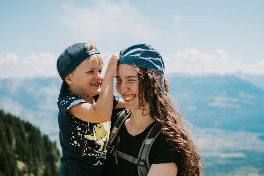 Katie Phillips (Soulfull Photographs) the photographer holding a kid in Switzerland on a hike