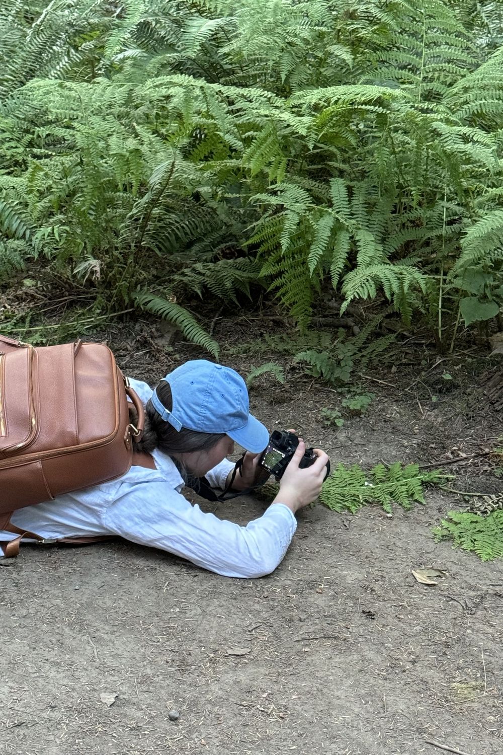 Katie Phillips (Soulfull Photographs) the photographer in Cathedral Groves, Vancouver Island on ground taking ring photos