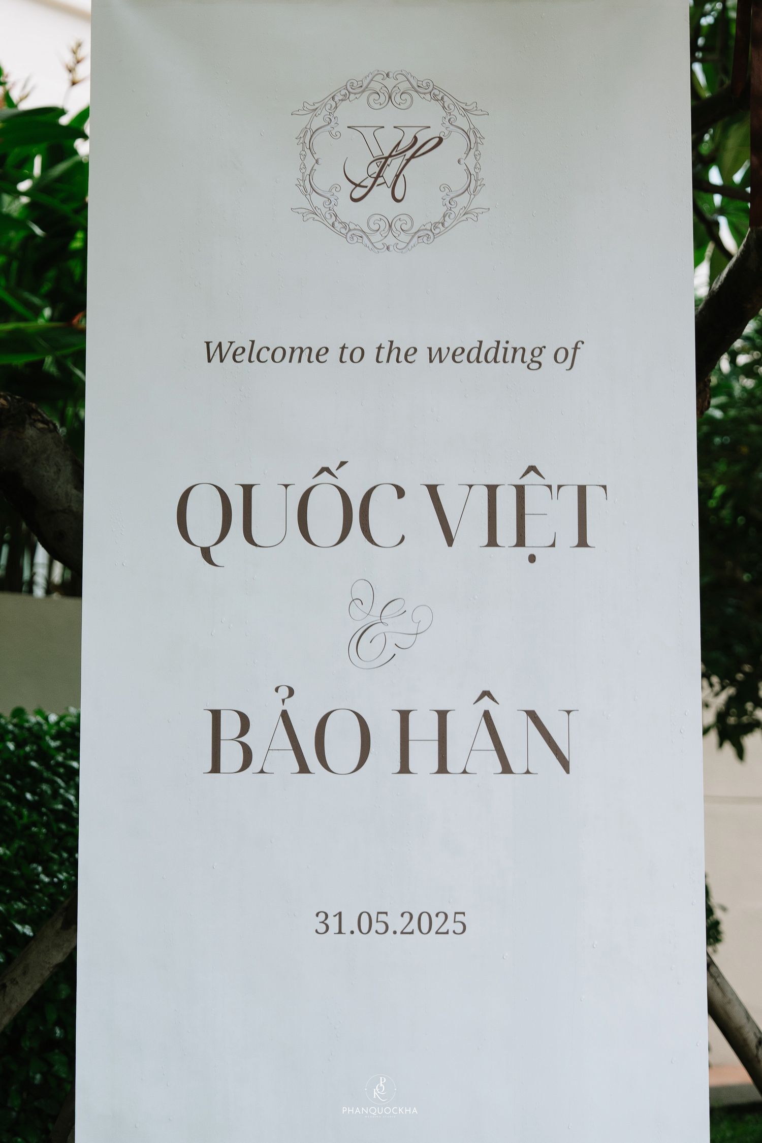 Elegant wedding welcome sign for Quoc Viet and Bao Han on May 31, 2025, with monogram crest.