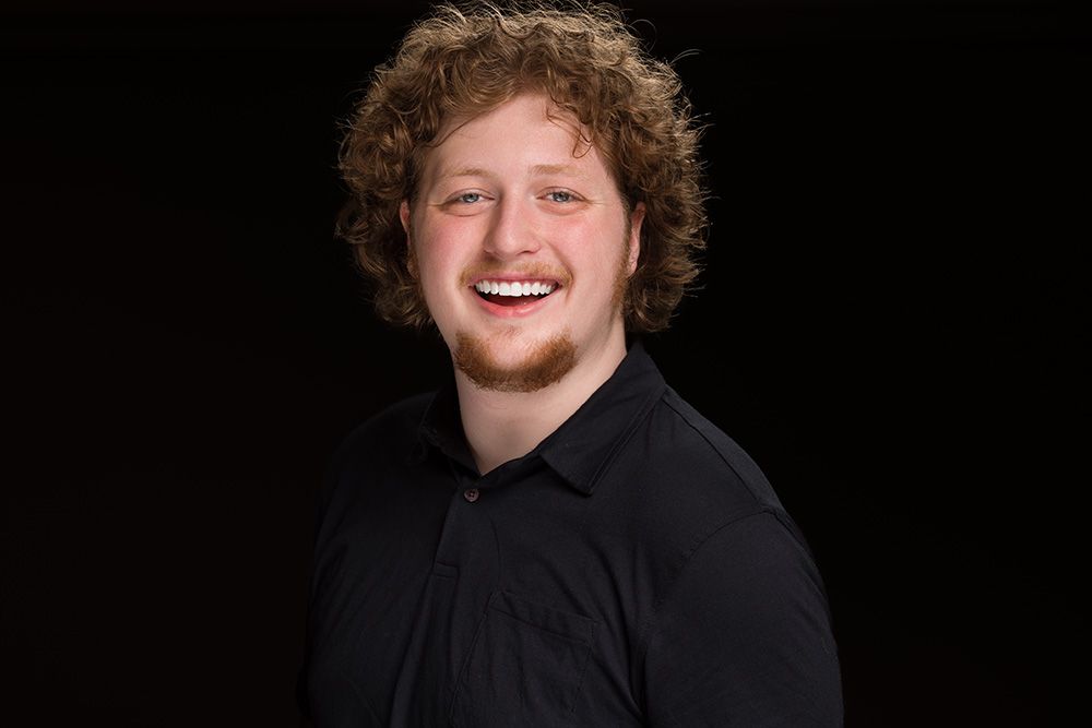 A series of black and white portrait photos showing someone with curly hair against a dark background.