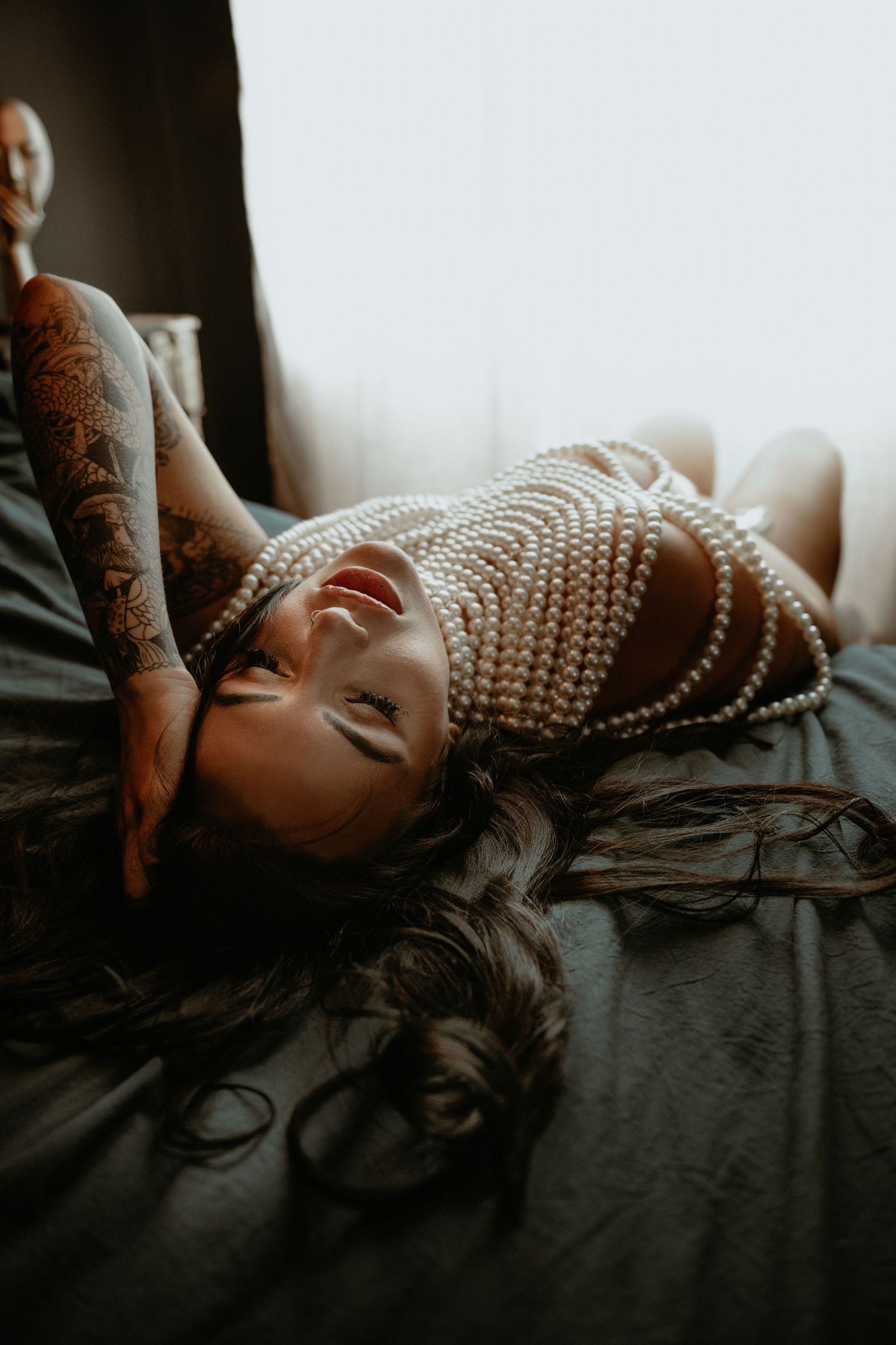 Elegant Boudoir photo of woman in a pearl top.