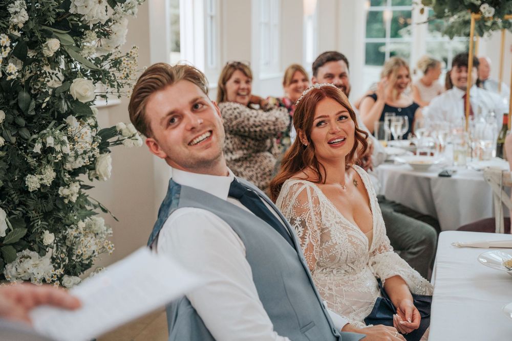 Groom laughing during best man speech at Rockbeare Manor reception