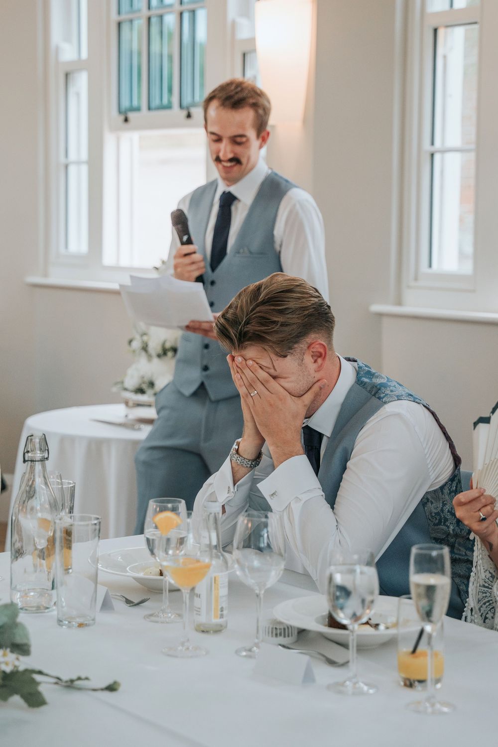 Groom laughing during best man speech at Rockbeare Manor reception