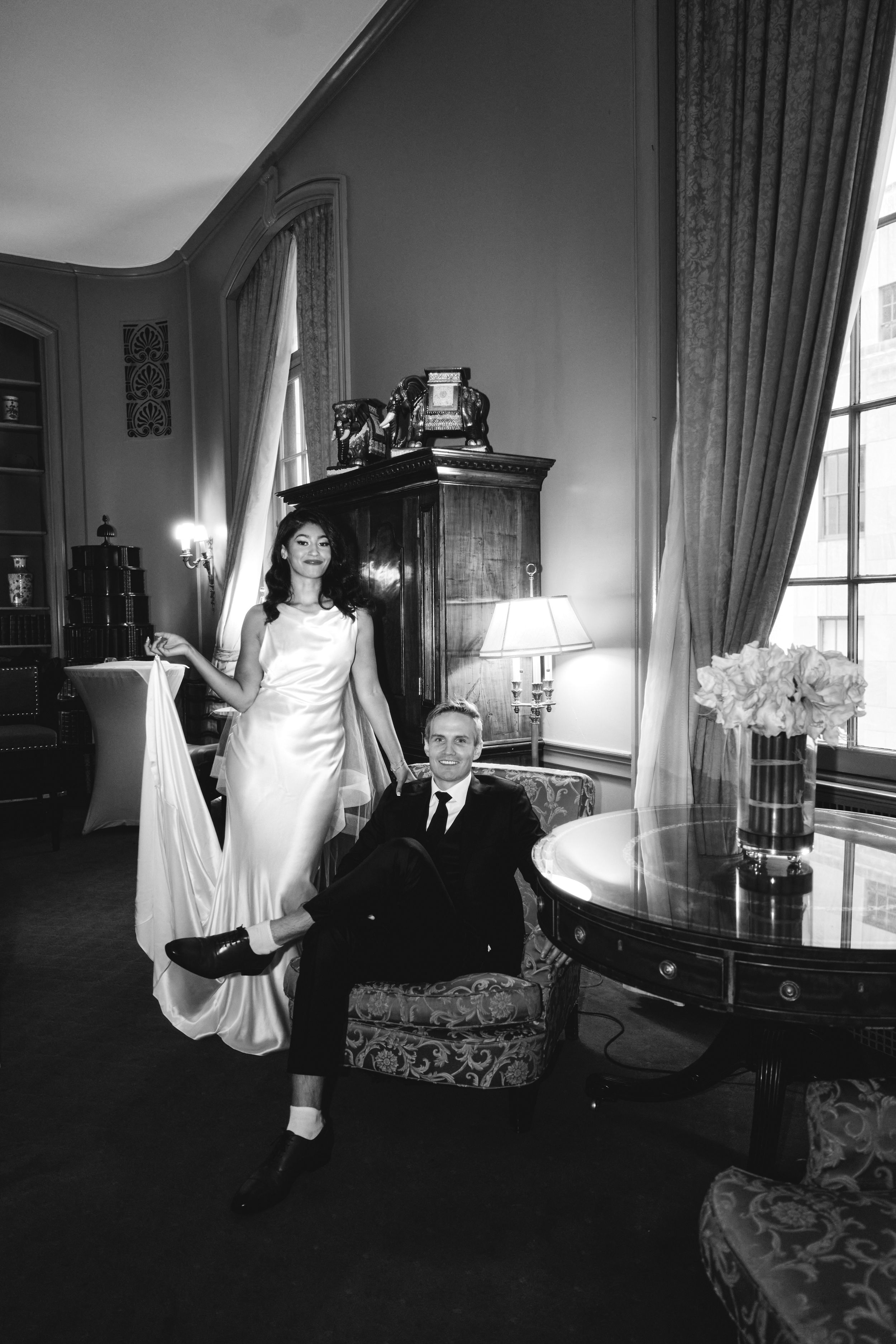 Elegant black and white portrait in a classic room with vintage furniture.