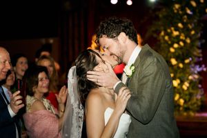 Wedding celebration moment with guests surrounding the couple during an evening reception.