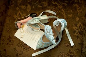 Wedding dress and accessories laid out delicately on a textured brown background.