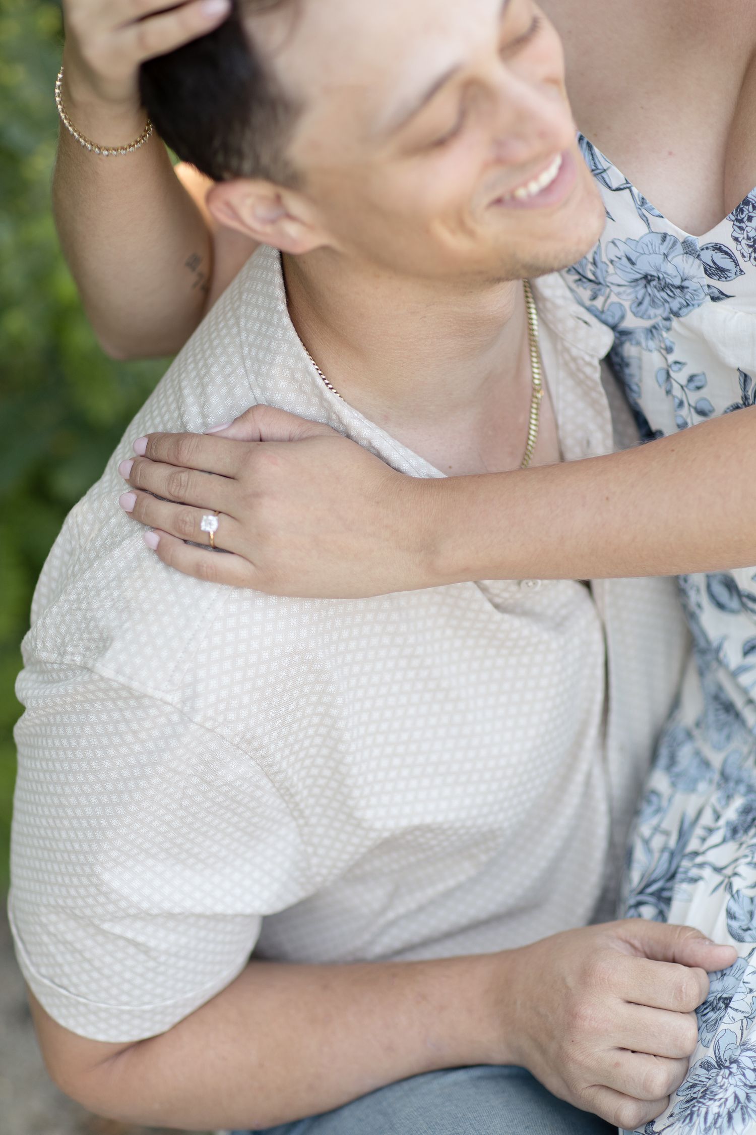 A close-up shot shows a tender embrace between two people, with one wearing a white textured shirt and sharing a joyful moment.