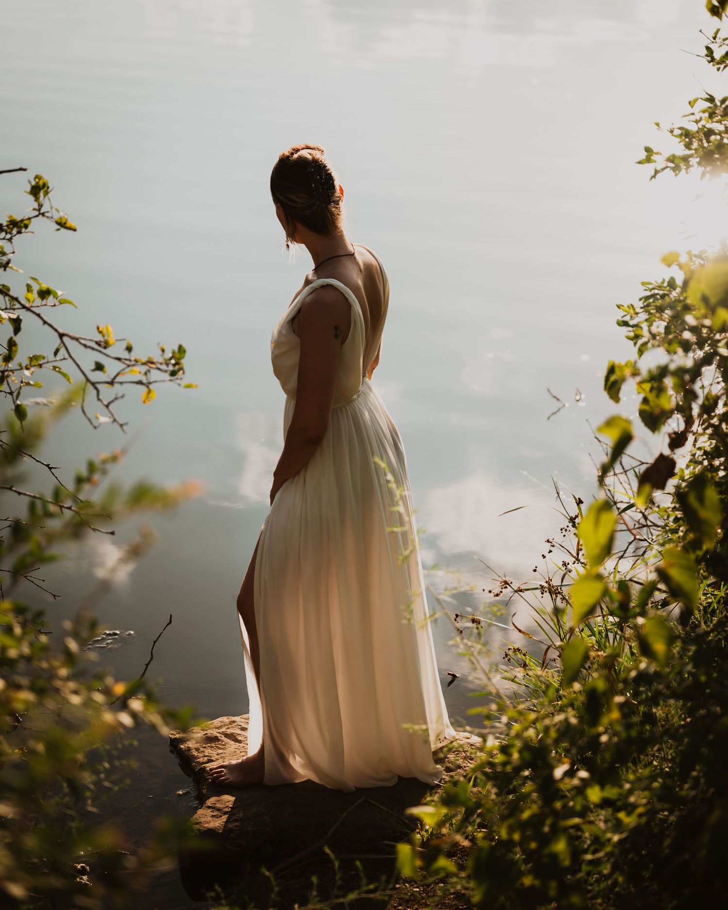 Portrait photograph taken in a moody forest setting with bokeh lighting effects in the background.