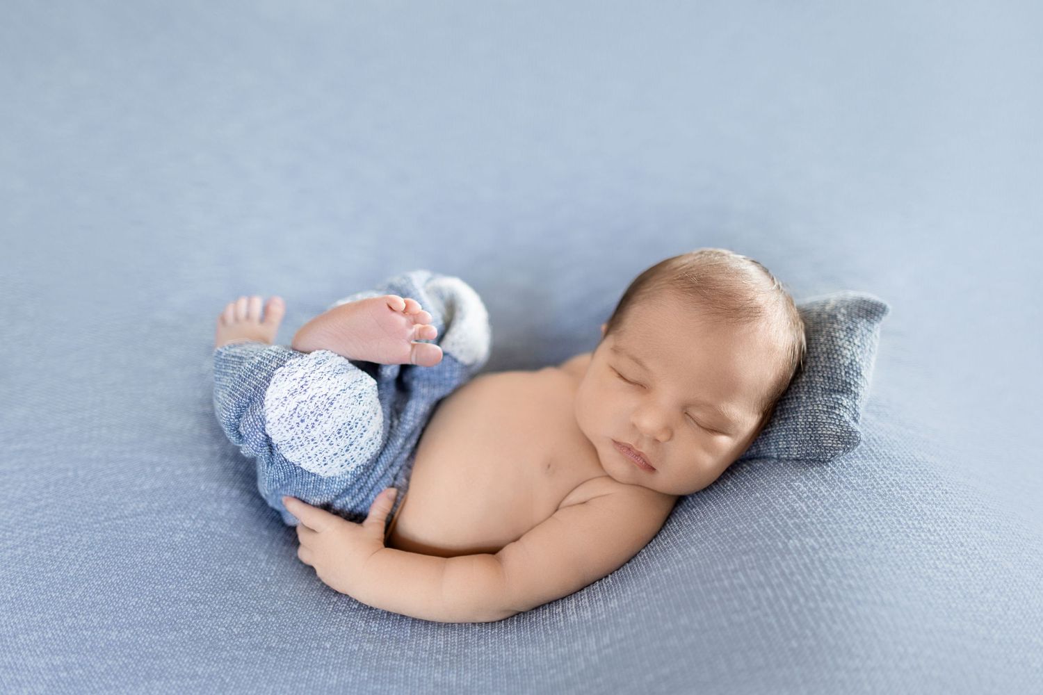 Newborn baby resting peacefully on light blue blanket wearing cozy gray knit hat. Photos by Tampa Photographer DigitalMyst Photography