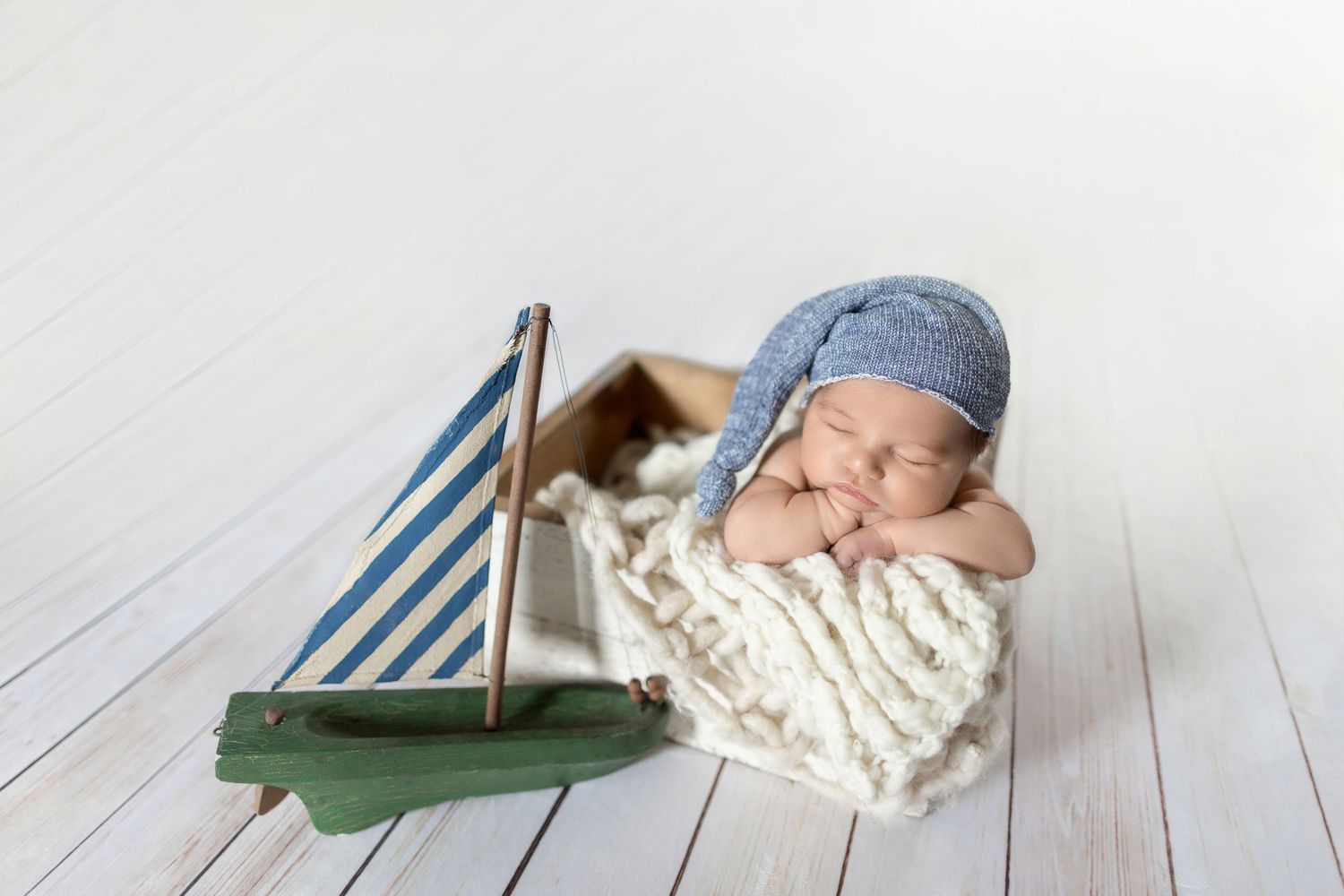 Newborn baby sleeping in rustic wooden crate with white blanket and nautical decor. Photo by Dani De La Rosa, DigitalMyst Photography