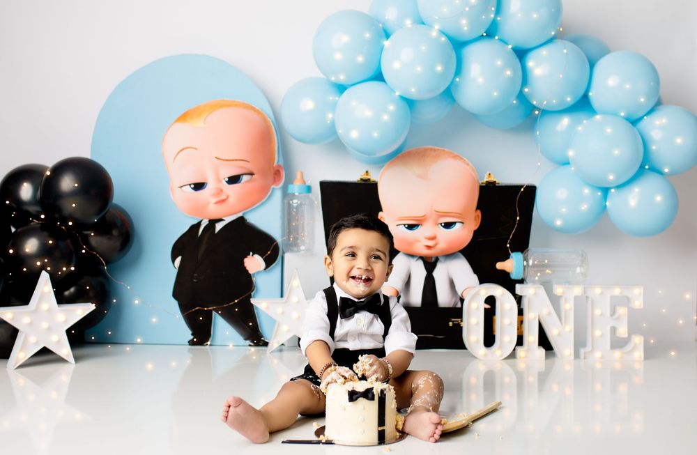 First birthday party setup with Boss Baby theme featuring black and blue balloon arch, white star, and 'ONE' text decoration. boronia height