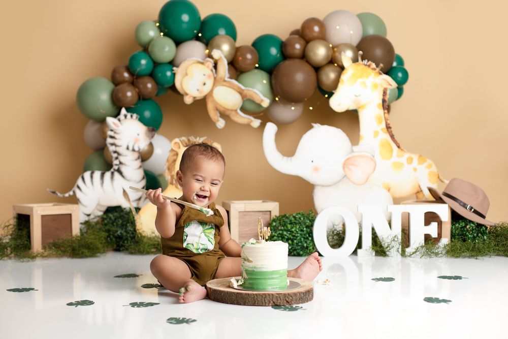 First birthday party setup with green and brown, baby safari animals, wild one. doolandella cake smash photographe