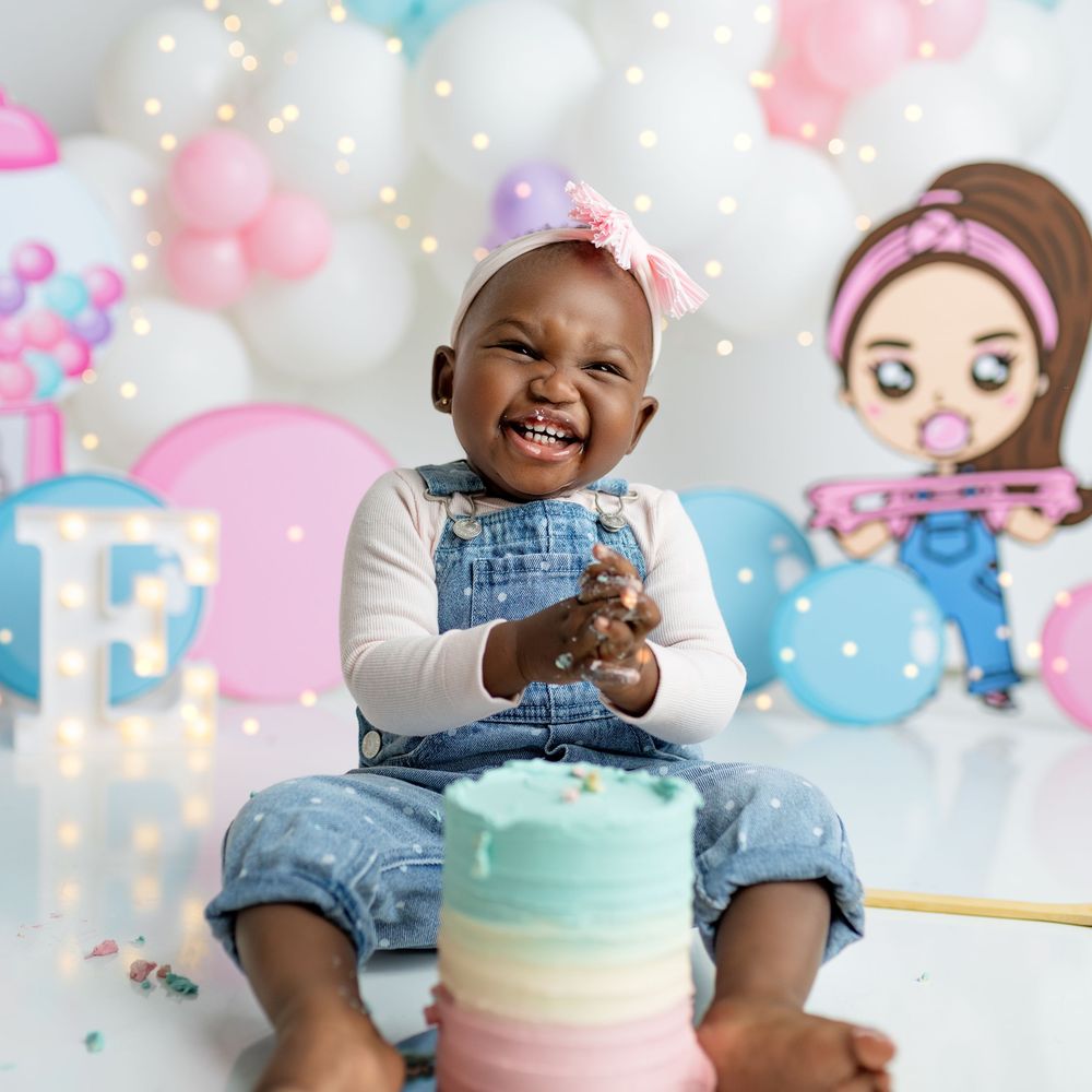 Festive birthday party scene with pastel balloons, decorations and a rainbow ombre cake against a dreamy backdrop. south sudanese first birt
