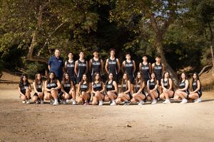 A group of people in matching uniforms sitting together on a sandy beach in a panoramic sequence of photos.
