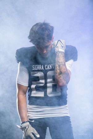 Football player in Sierra Canyon jersey number 20 posing in atmospheric smoke effect.