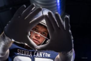 Football player making frame gesture with gloved hands showing Sierra Canyon branding.