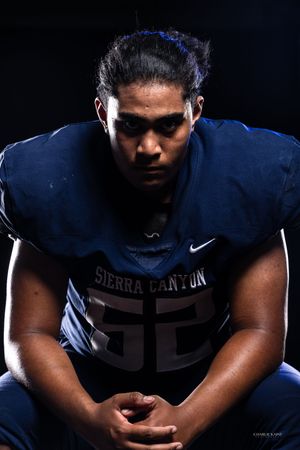 Football player in Sierra Canyon jersey 55 poses in dramatic lighting.