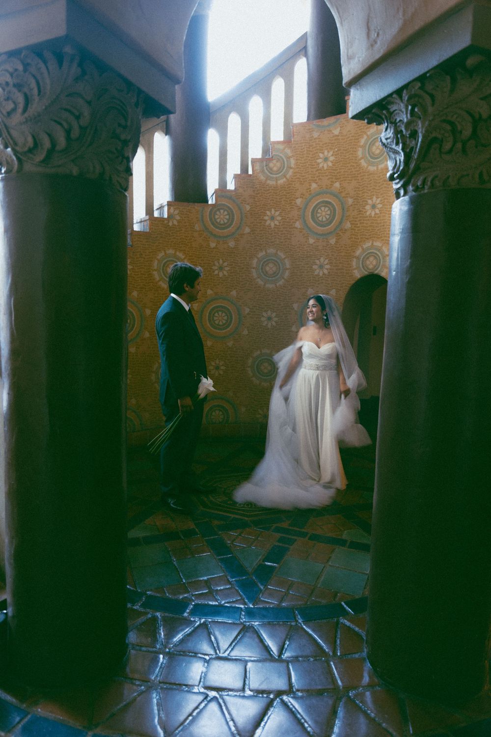 A vintage wedding scene in an ornate room with decorative tiled floor and patterned walls.