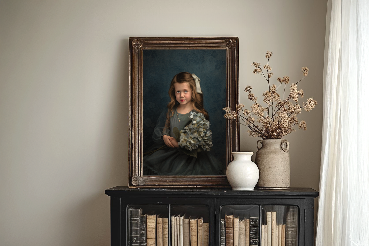 A framed fine art photo of a young girl holding flowers sits on a bookshelf with a vase of flowers.
