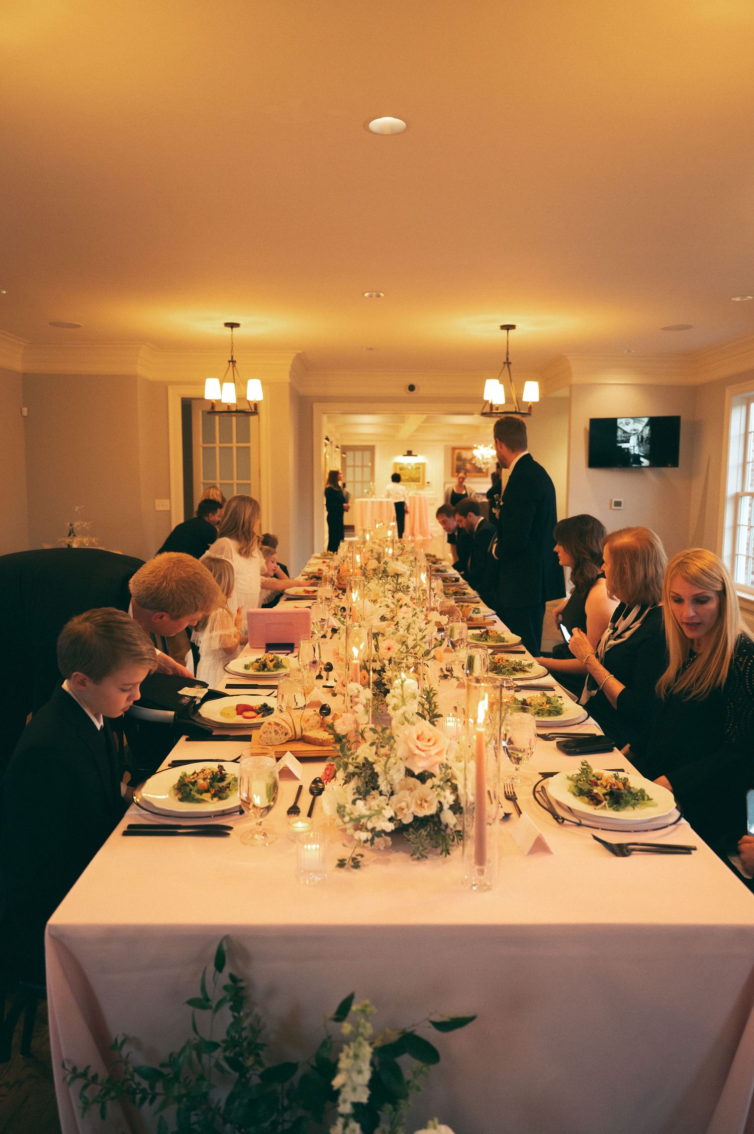 Formal wedding reception with elegant table settings and floral centerpieces.