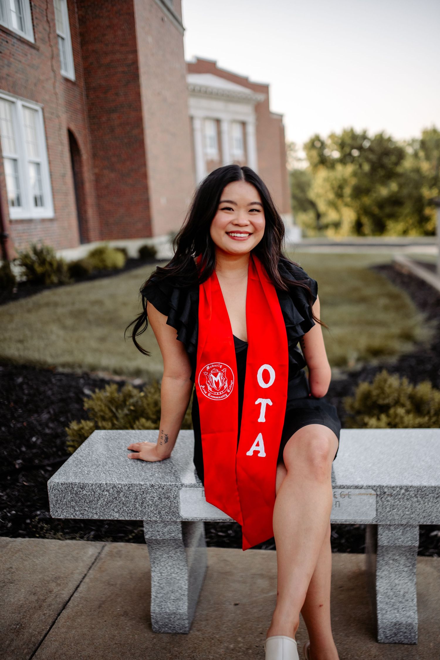 Graduation photo session with sash on the MACC campus, celebrating academic achievements in a memorable and picturesque setting.