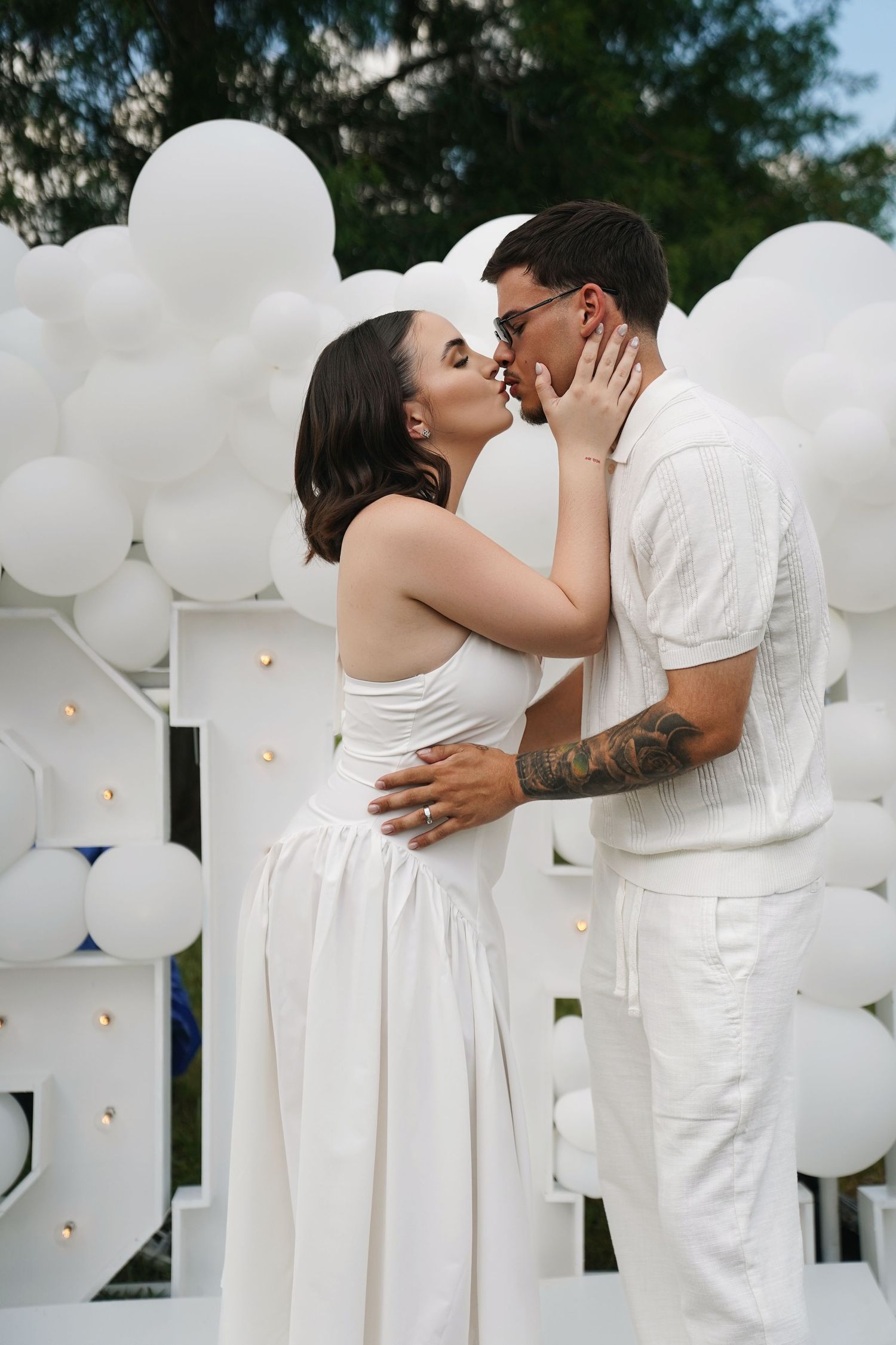 Artistic portrait with flowing white tulle fabric against minimal white backdrop.