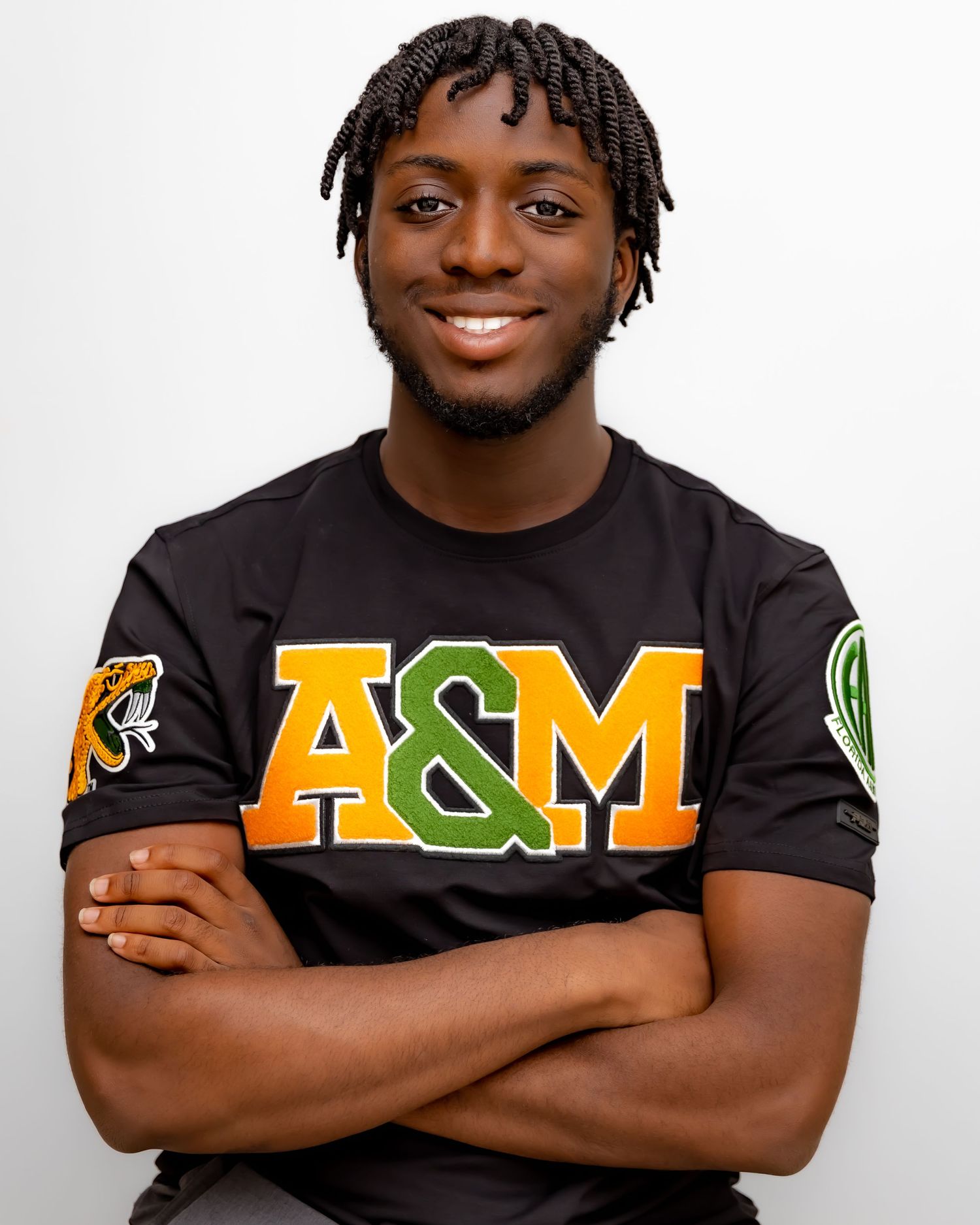 Portrait of person wearing A&M branded black t-shirt with arms crossed.