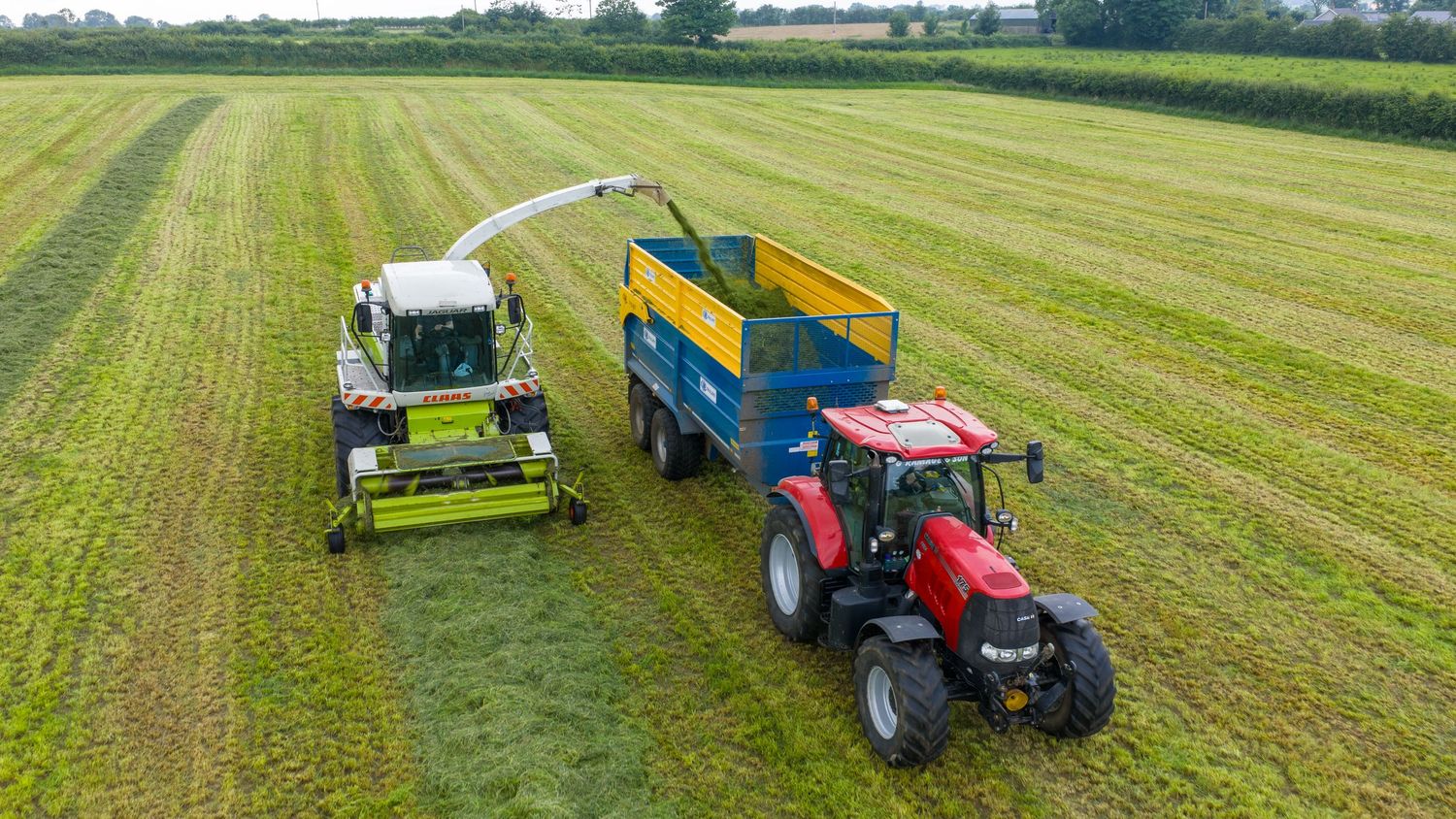 A series of farming equipment working in green agricultural fields with mowers and tractors harvesting hay crops.