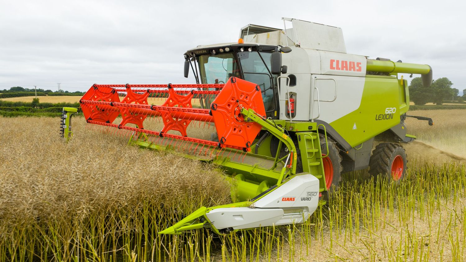 Modern combine harvester machinery working in wheat fields during summer harvest season.