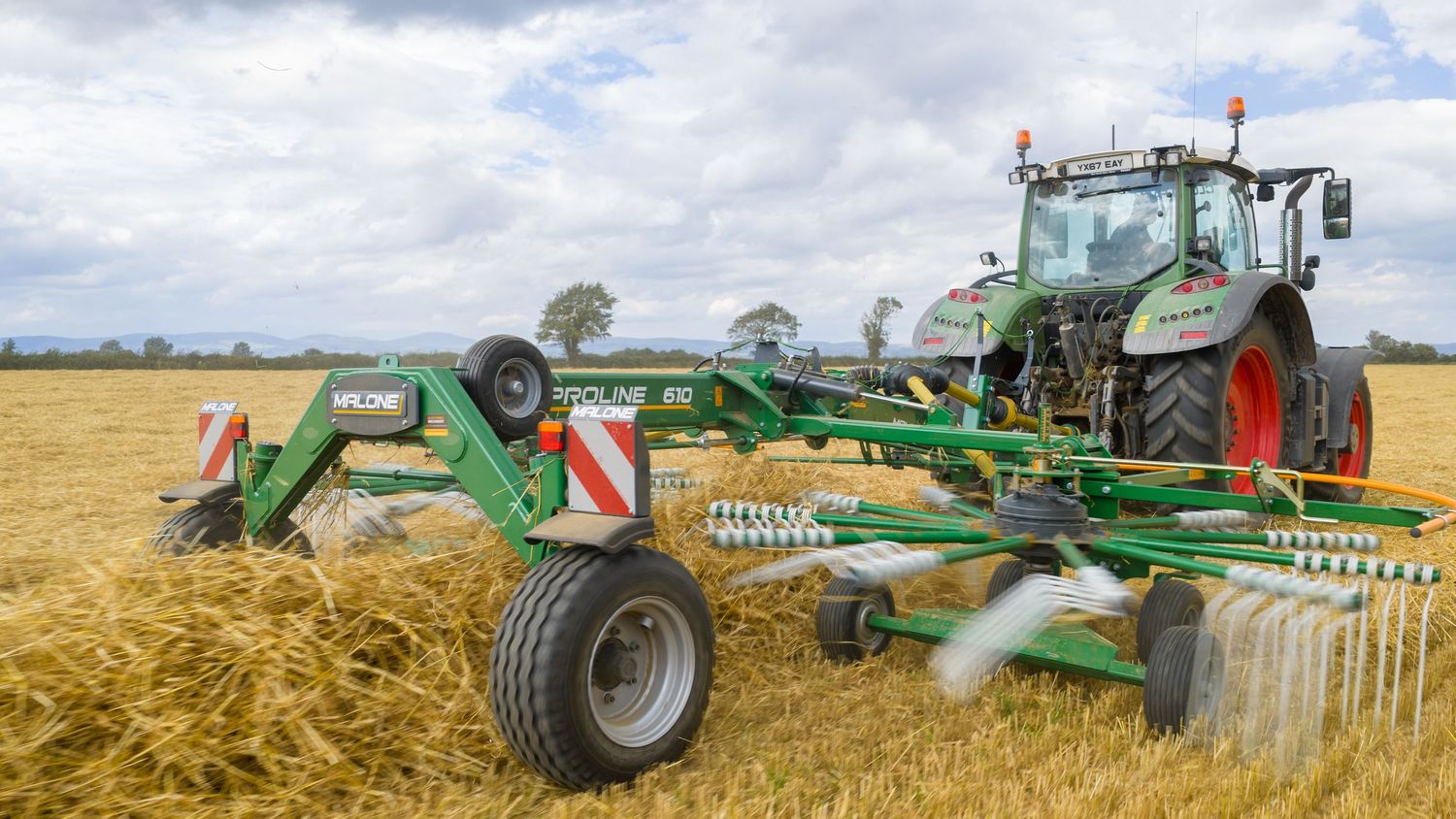 Agricultural machinery including tractors and harvesters working in golden wheat fields during harvest season.