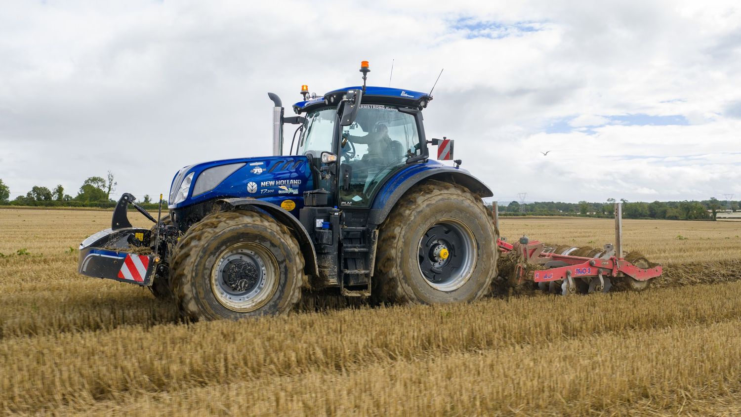 Farm tractors and equipment working together in a wheat field to harvest and prepare the soil for the next growing season.