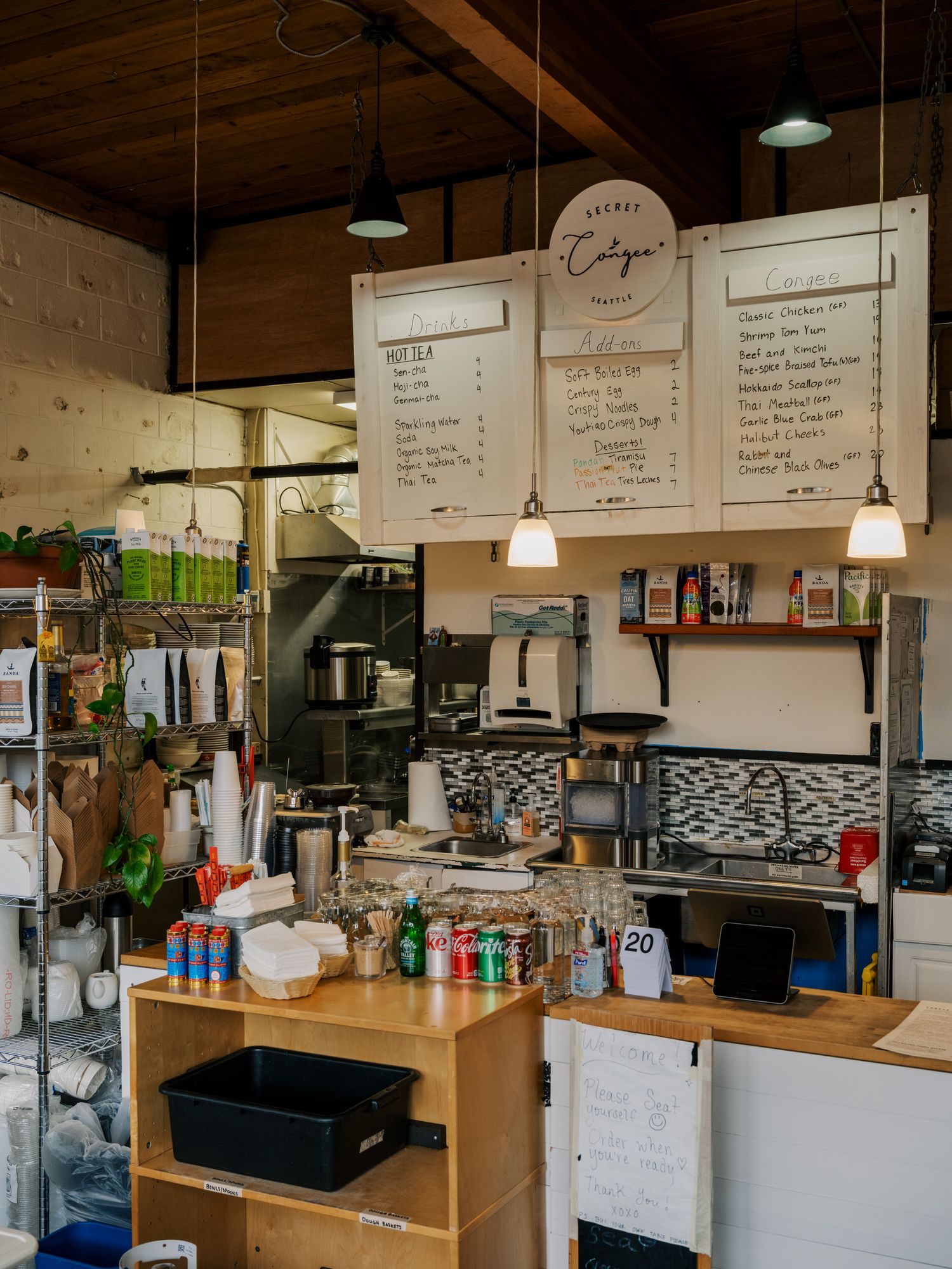 Interior view of a cozy coffee shop counter with wooden decor, menu boards, and coffee making equipment on display.