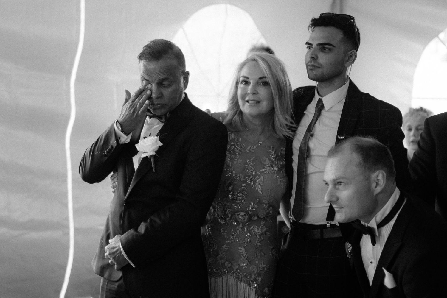 Black and white photo showing people gathered in formal attire at an elegant event with arched architectural details at Villa Malla.