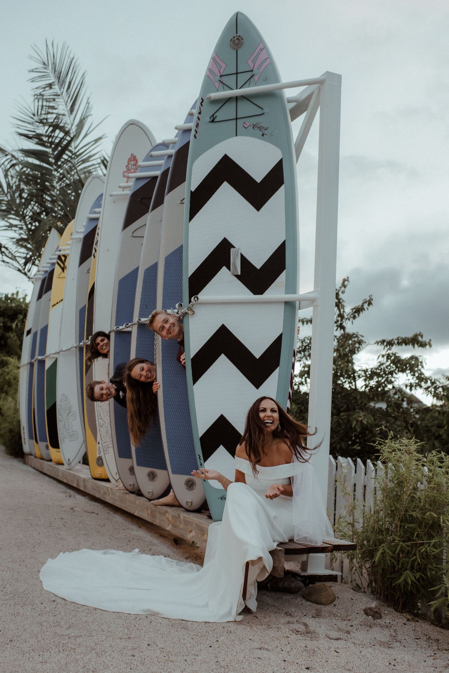 A creative wedding photo with surfboards displayed in a row against an overcast sky at Villa Malla in Filtvet, Norway.