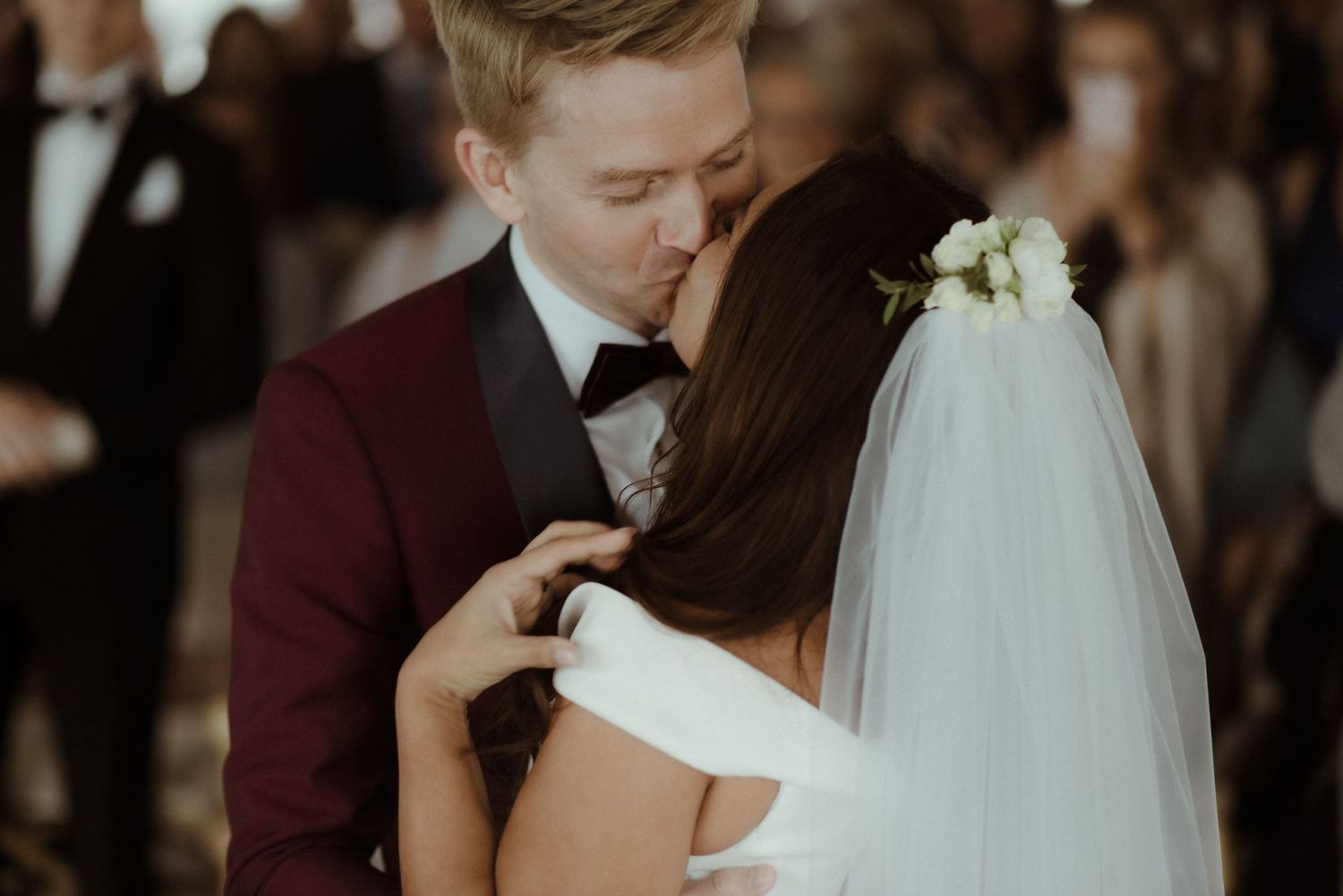 A romantic wedding moment captured with a couple embracing in soft light, with bride wearing traditional veil and white dress at Villa Malla