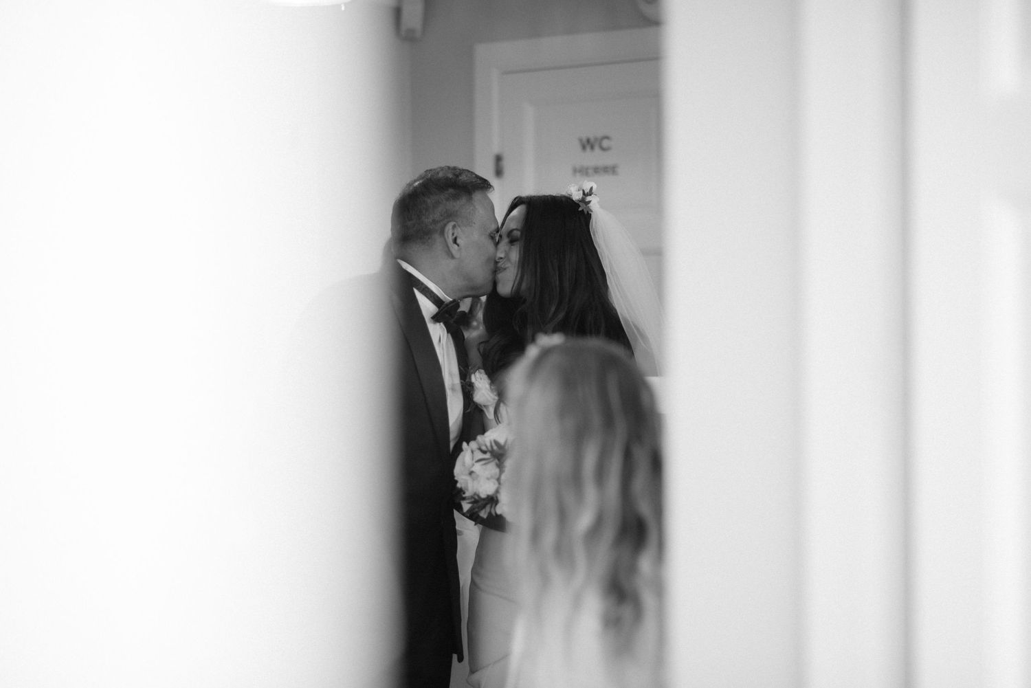 A romantic black and white wedding photo shows a couple sharing an intimate moment in a doorway at Villa Malla in Norway.