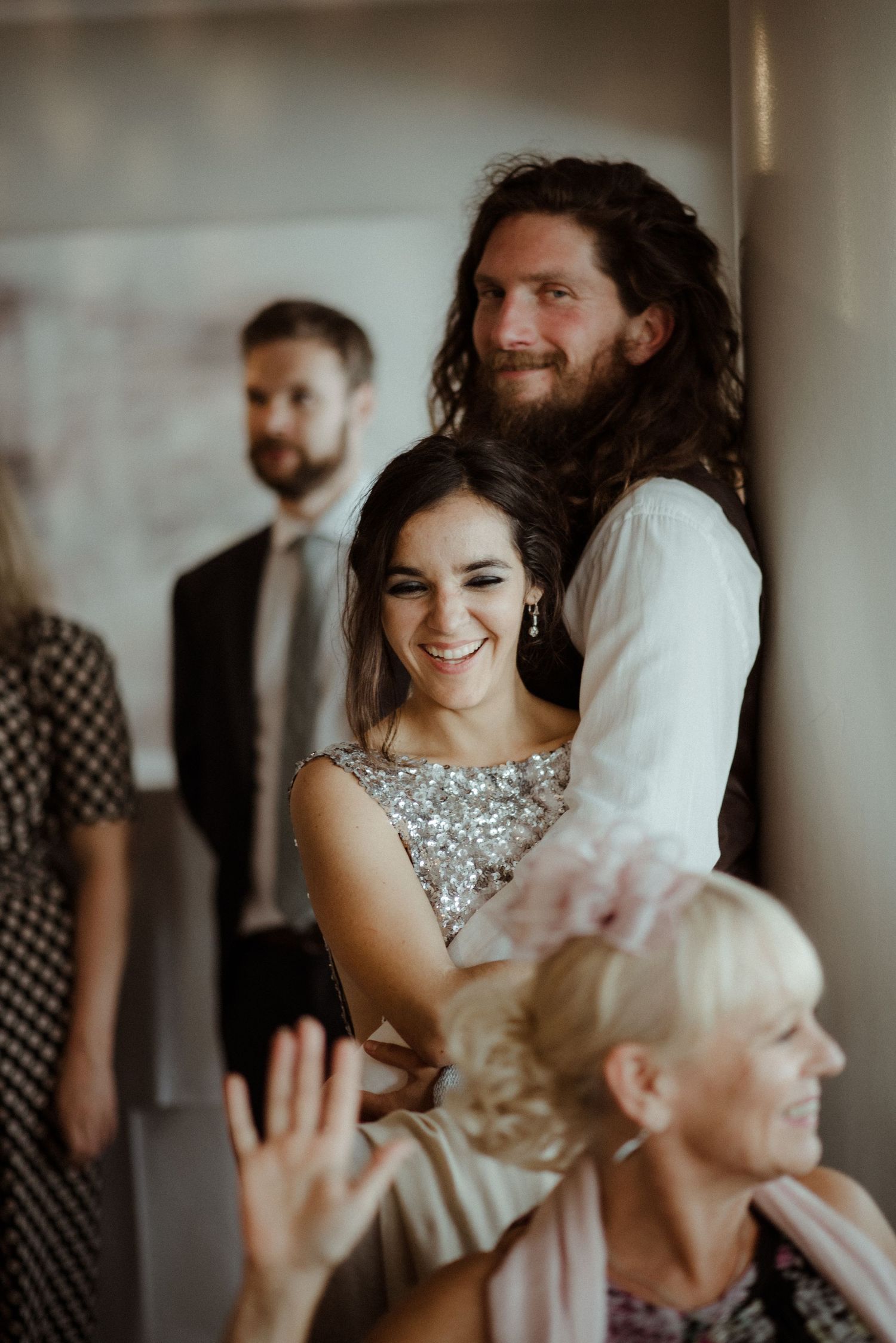 A joyful celebration moment at a wedding with people smiling and laughing together in an intimate indoor setting at Villa Malla in Filtvet,.