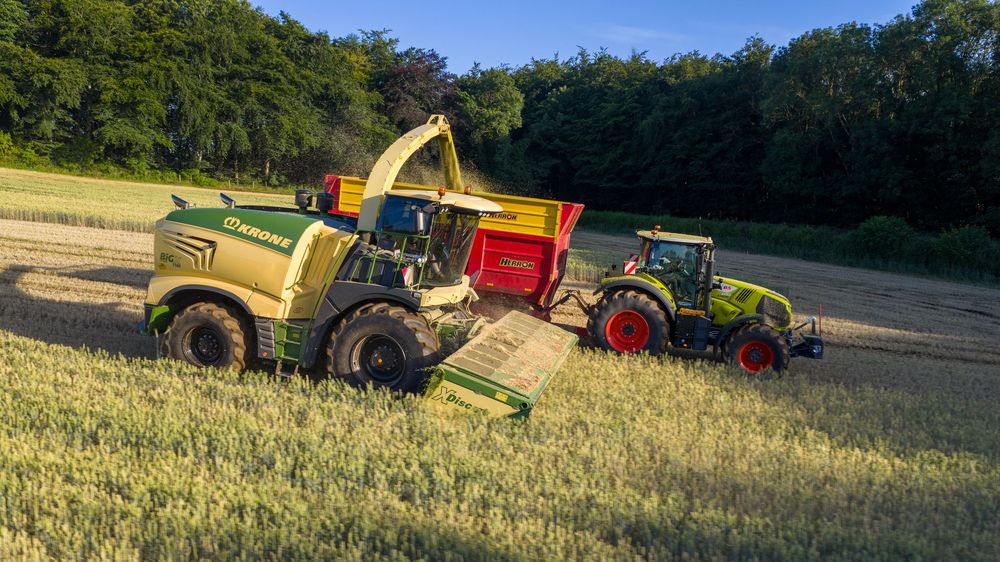 Agricultural machinery and tractors lined up in a field during harvest season.