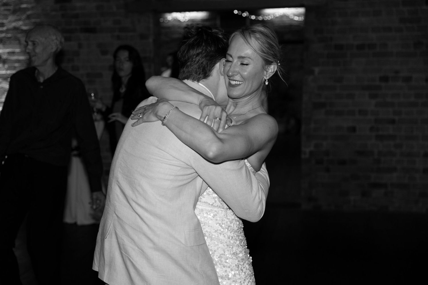Black and white photo captures intimate dance moment at wedding reception.