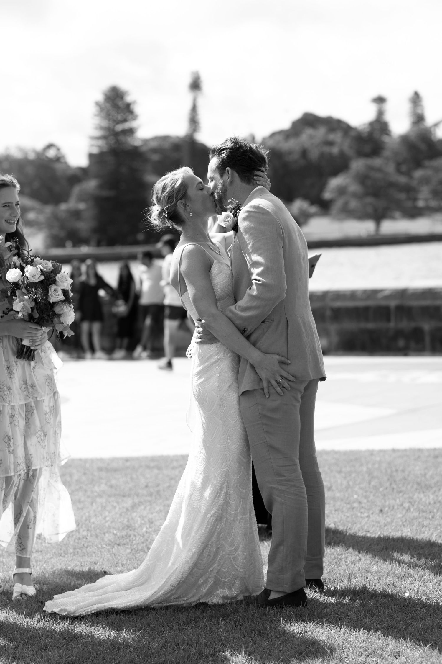 Black and white wedding photo showing an intimate moment during an outdoor ceremony.