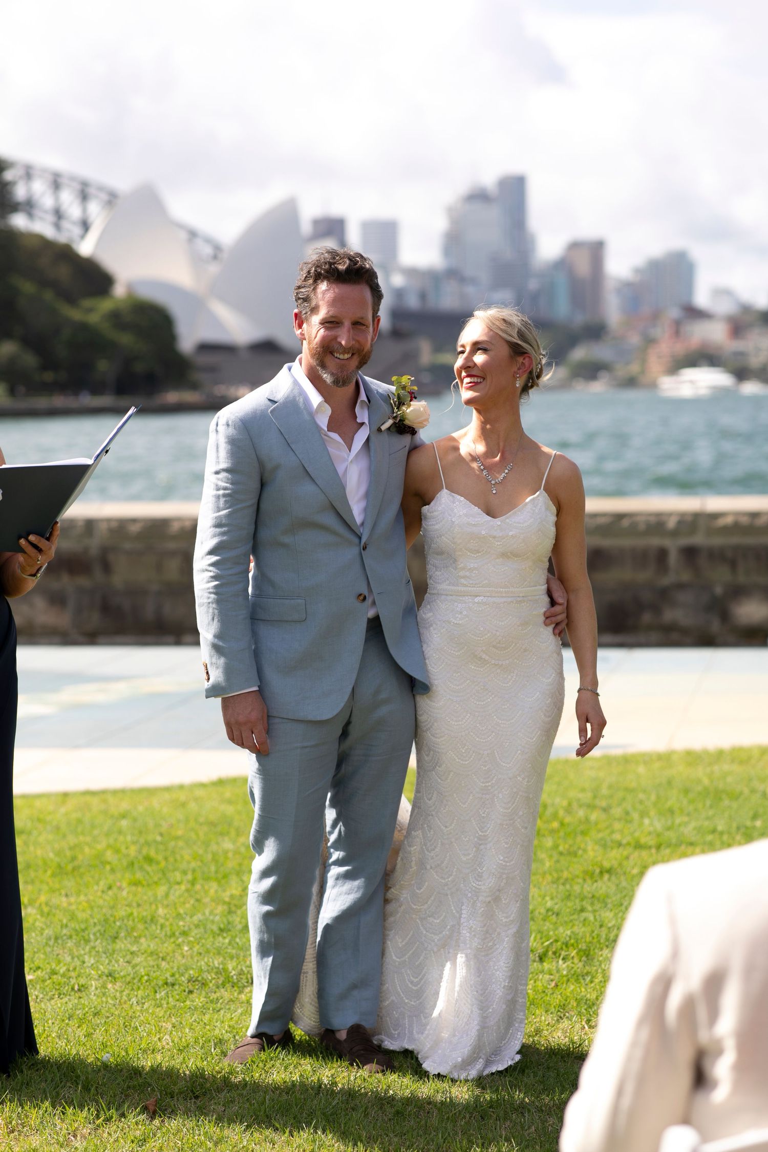 Newlyweds pose together with Sydney Harbour Bridge and Opera House in background.