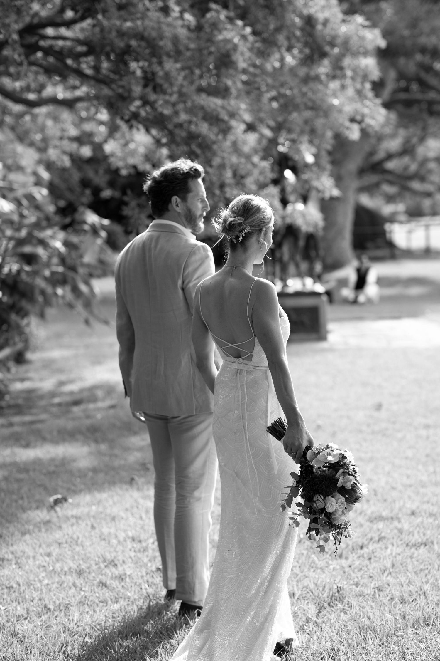 Black and white photo of a couple walking together on garden grounds.