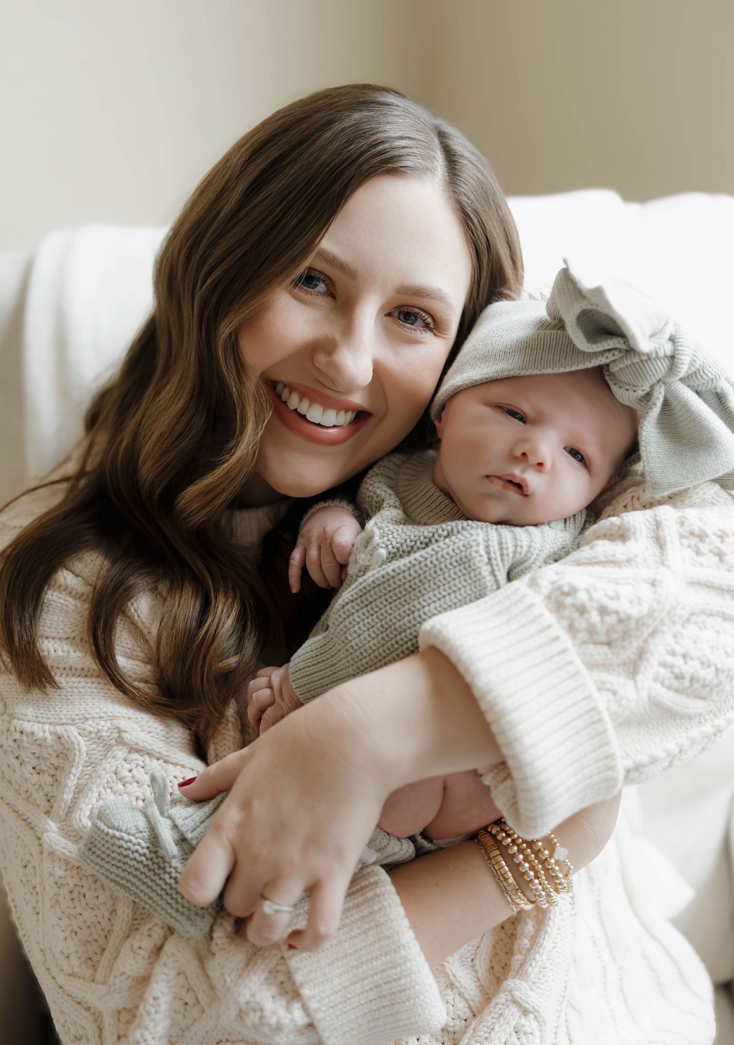 A tender moment captured in soft lighting showing affectionate embraces in cozy white knit sweaters.